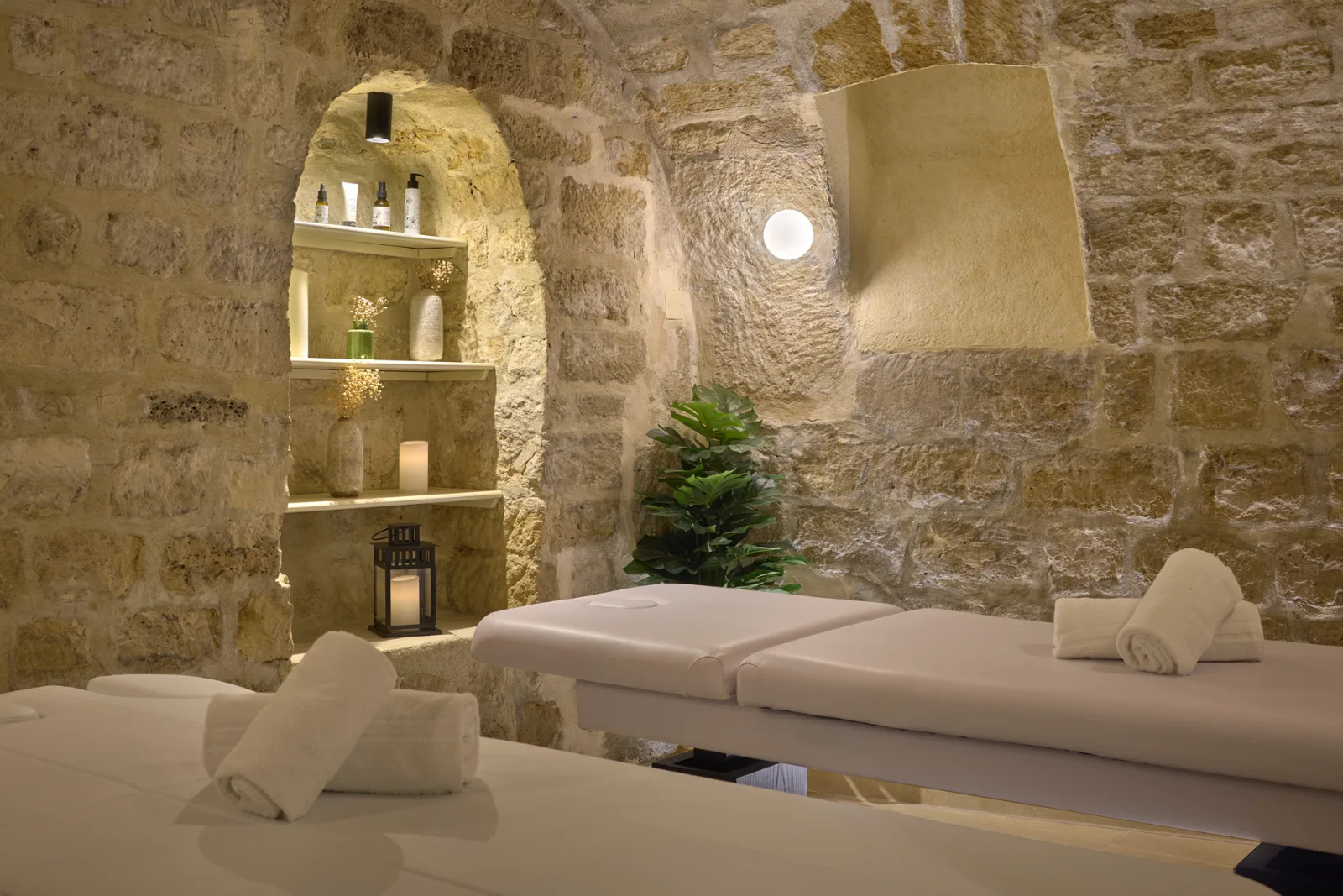 Cabine de massage duo sous voûte en pierre dans un spa d'hôtel à Paris