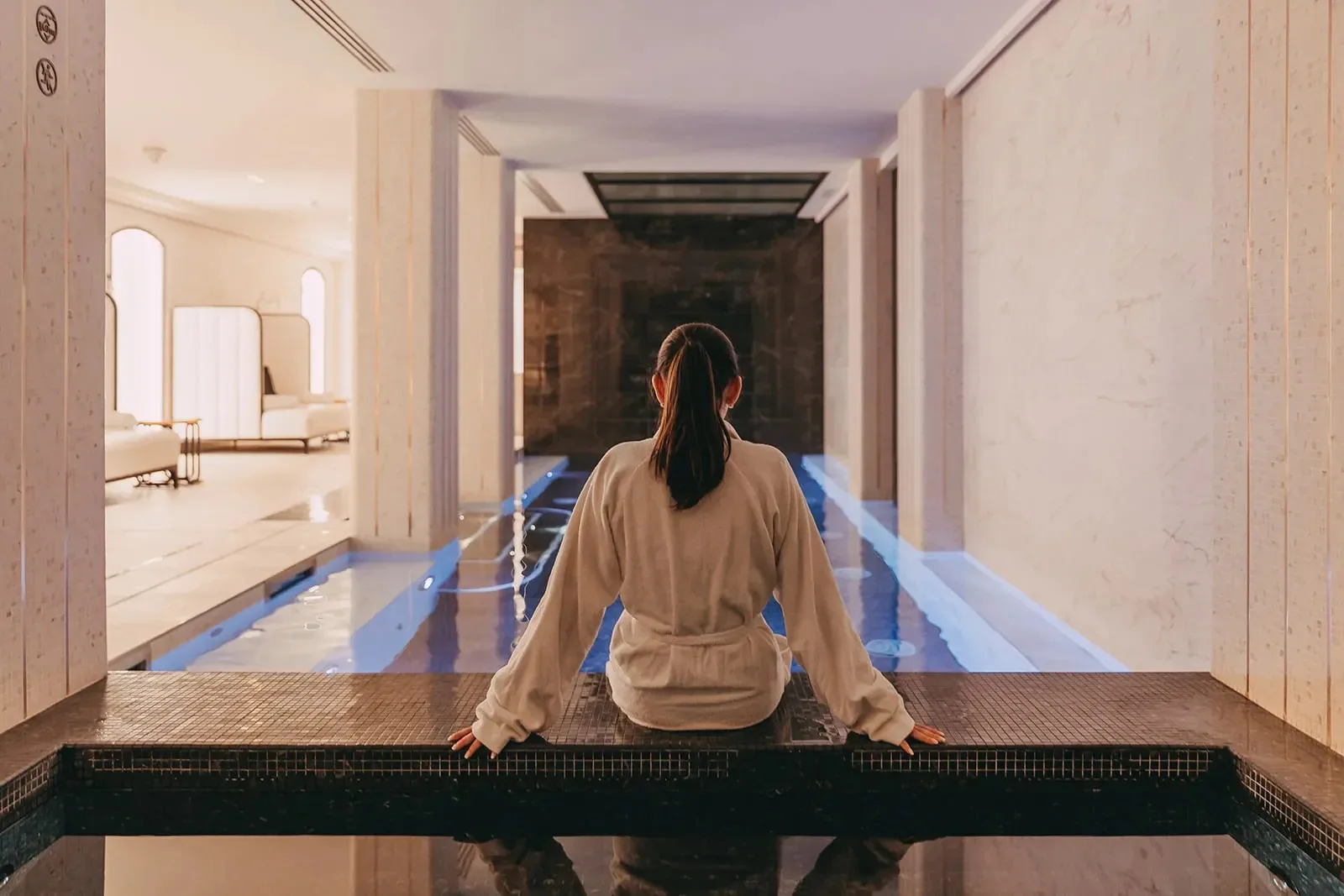 Cliente qui se détend au bord du bassin du Spa Narcisse Blanc à Paris